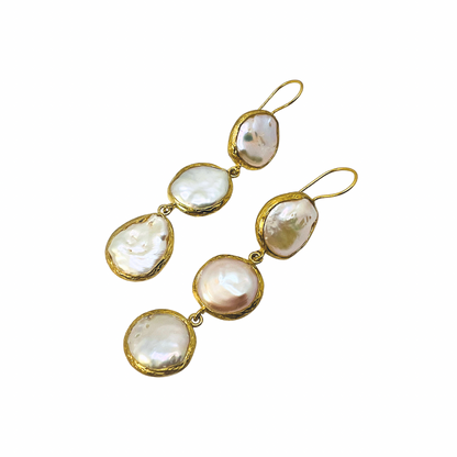 Gold and pearl drop earrings on a white background